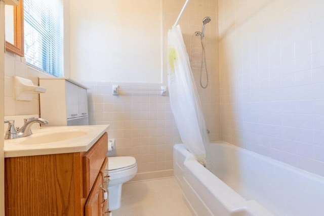 full bathroom featuring toilet, vanity, tile walls, and shower / tub combo