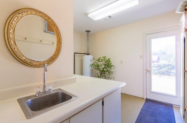 kitchen with water heater, decorative light fixtures, plenty of natural light, and sink