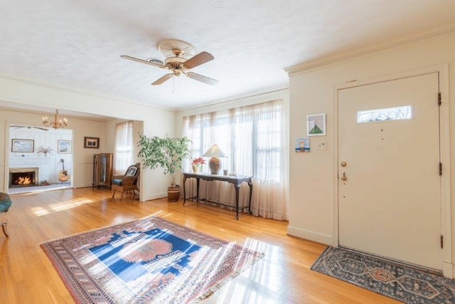 entrance foyer with radiator, wood-type flooring, ornamental molding, and a textured ceiling