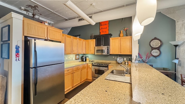 kitchen featuring appliances with stainless steel finishes, light brown cabinets, sink, kitchen peninsula, and light stone counters