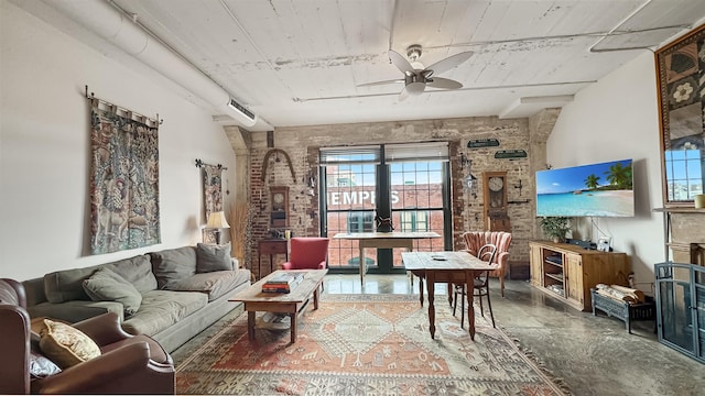 living room featuring ceiling fan, brick wall, and concrete flooring