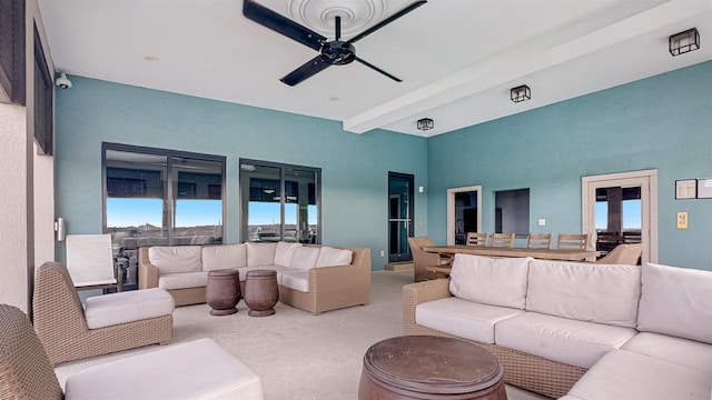 living room with ceiling fan, beam ceiling, and light colored carpet