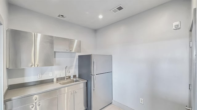 kitchen featuring sink and stainless steel refrigerator