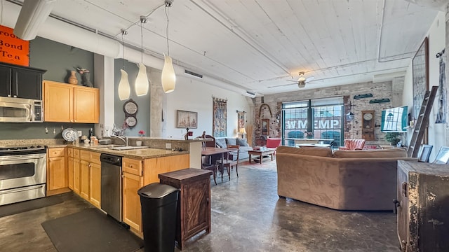 kitchen with light brown cabinets, appliances with stainless steel finishes, kitchen peninsula, and decorative light fixtures