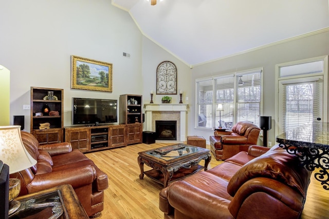 living room featuring vaulted ceiling, light hardwood / wood-style flooring, and crown molding