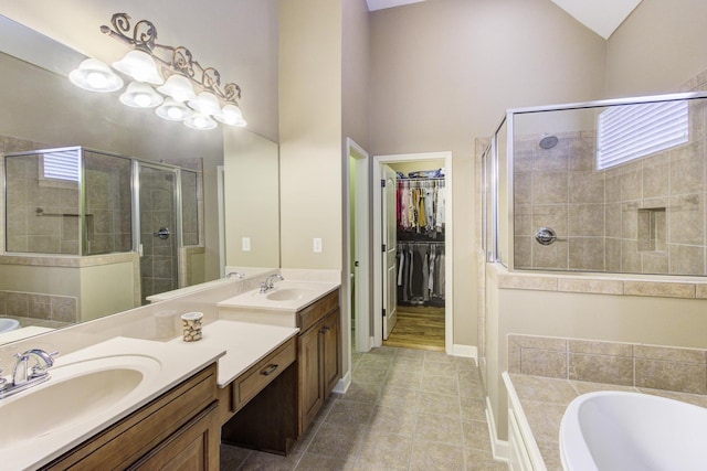 bathroom with tile patterned floors, vanity, independent shower and bath, and vaulted ceiling