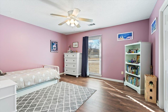 bedroom featuring ceiling fan, a textured ceiling, and dark hardwood / wood-style flooring