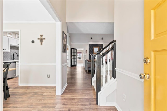 foyer entrance featuring sink, hardwood / wood-style floors, and crown molding