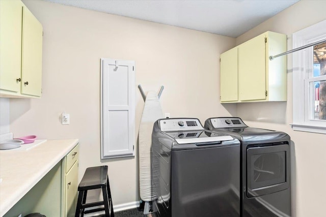 washroom featuring cabinets and separate washer and dryer