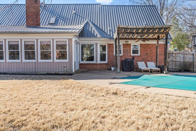 back of property featuring a covered pool, a patio, and a pergola