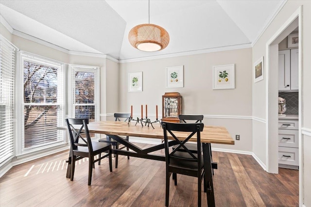 dining area with crown molding, dark hardwood / wood-style flooring, and lofted ceiling