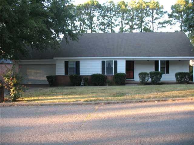 single story home featuring a garage and a front lawn