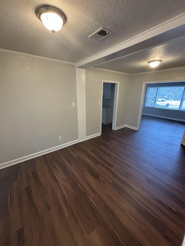 empty room with crown molding, dark wood-type flooring, and a textured ceiling