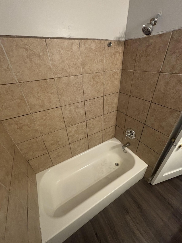 bathroom with hardwood / wood-style floors and tiled shower / bath