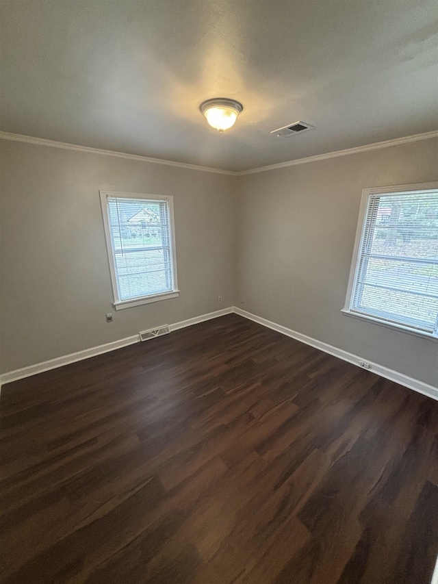 empty room featuring dark hardwood / wood-style floors and crown molding