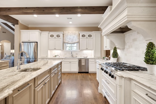 kitchen with appliances with stainless steel finishes, custom exhaust hood, sink, backsplash, and white cabinets