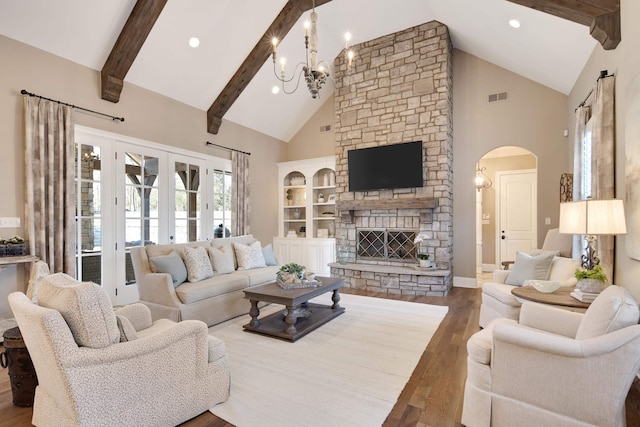 living room featuring french doors, dark wood-type flooring, a fireplace, high vaulted ceiling, and a notable chandelier