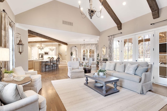 living room featuring a notable chandelier, french doors, high vaulted ceiling, and light hardwood / wood-style floors