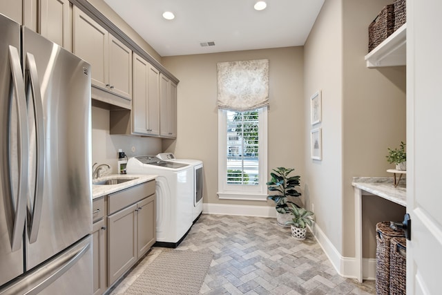 laundry area featuring sink, cabinets, and separate washer and dryer