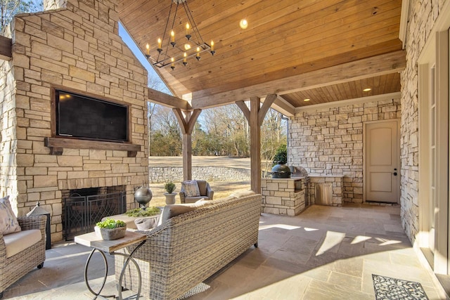 view of patio / terrace featuring an outdoor stone fireplace and area for grilling