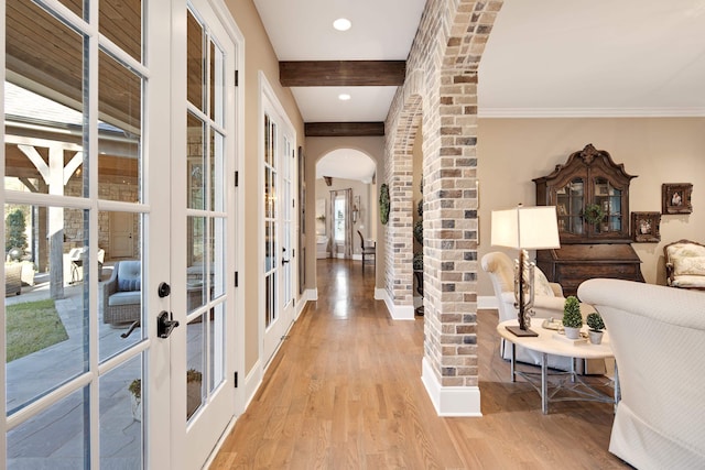 hallway featuring light hardwood / wood-style floors and beamed ceiling