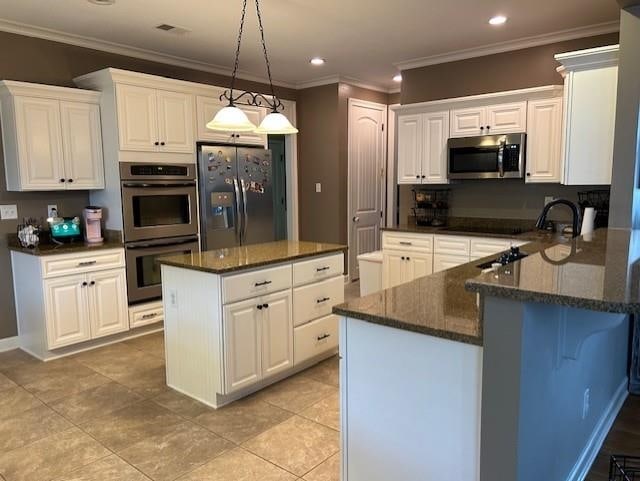 kitchen featuring stainless steel appliances and white cabinetry