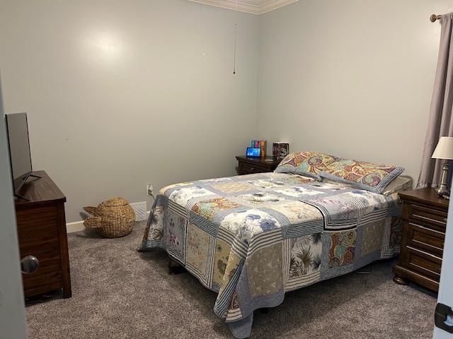 bedroom featuring crown molding and carpet floors