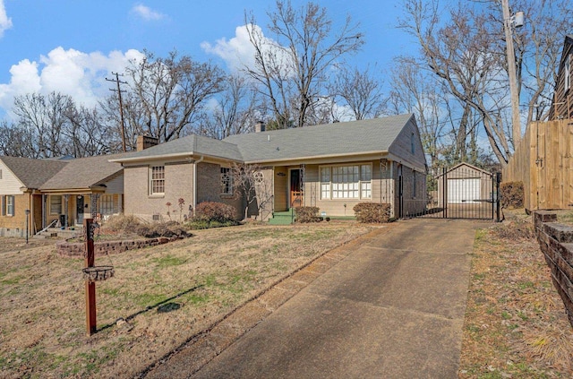 single story home featuring an outbuilding, a garage, and a front lawn