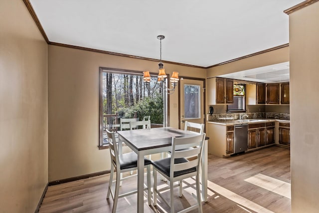 dining room featuring light wood-type flooring, an inviting chandelier, and sink