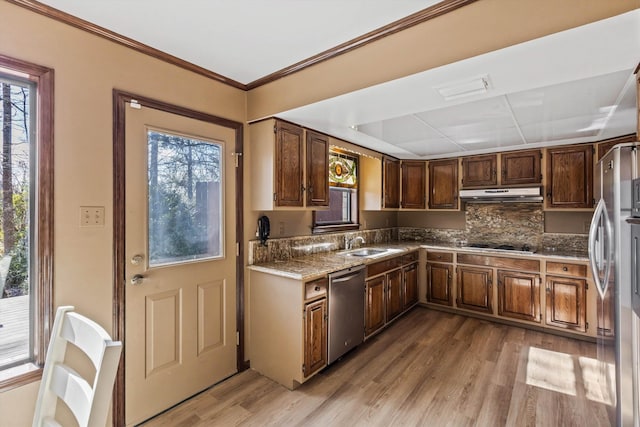 kitchen with light hardwood / wood-style floors, sink, stainless steel appliances, and tasteful backsplash