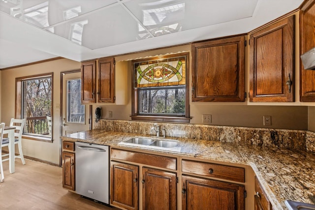 kitchen featuring sink, stainless steel dishwasher, and light hardwood / wood-style flooring