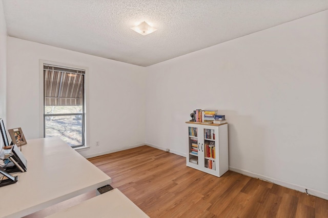 office area with hardwood / wood-style floors and a textured ceiling