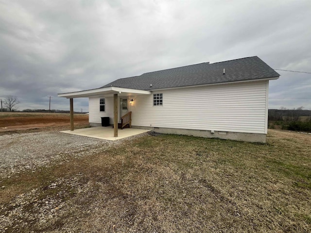 back of property featuring a patio area and a lawn