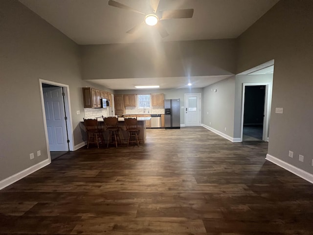 unfurnished living room featuring dark hardwood / wood-style floors and ceiling fan