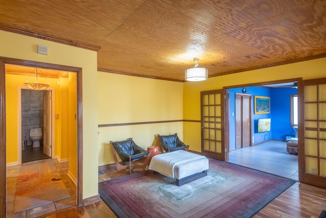 bedroom with wooden ceiling, hardwood / wood-style floors, crown molding, and ensuite bath