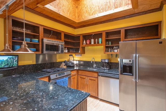 kitchen with pendant lighting, dark stone countertops, appliances with stainless steel finishes, and sink