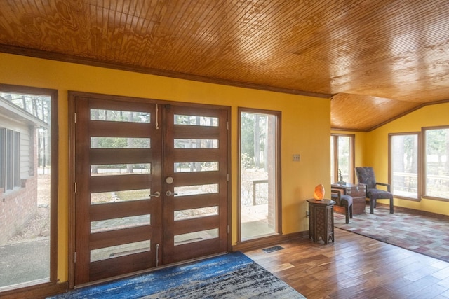 foyer with lofted ceiling, french doors, hardwood / wood-style flooring, wooden ceiling, and crown molding