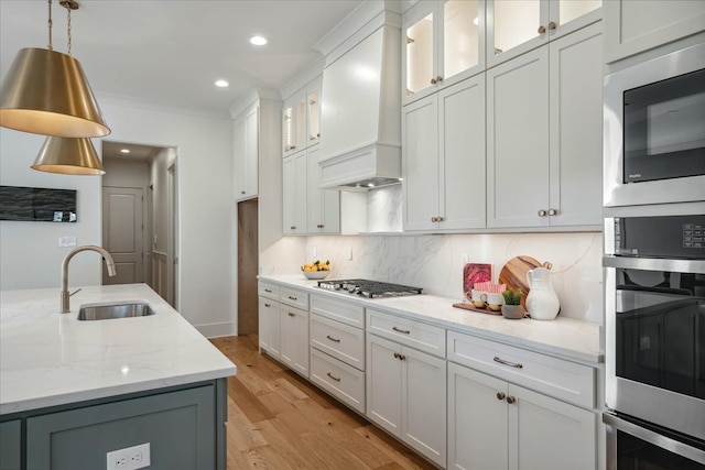 kitchen featuring sink, white cabinets, black microwave, and custom range hood