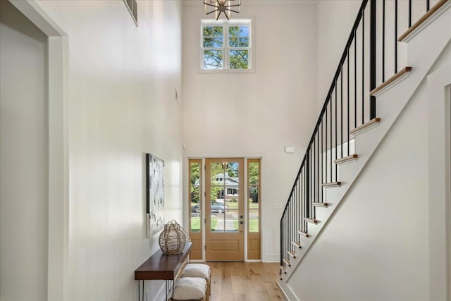 foyer entrance featuring light hardwood / wood-style floors and a high ceiling