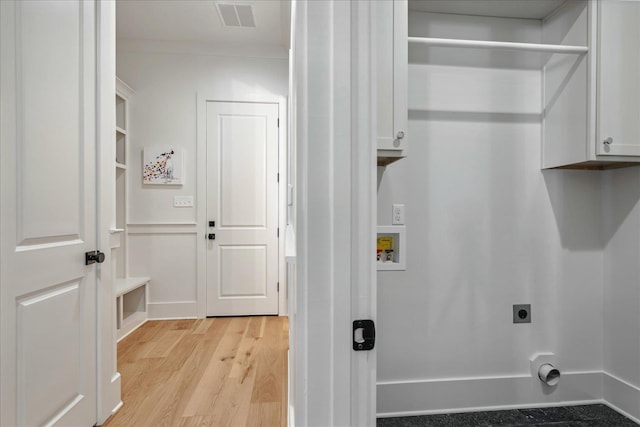 laundry room with washer hookup, electric dryer hookup, light hardwood / wood-style floors, and cabinets