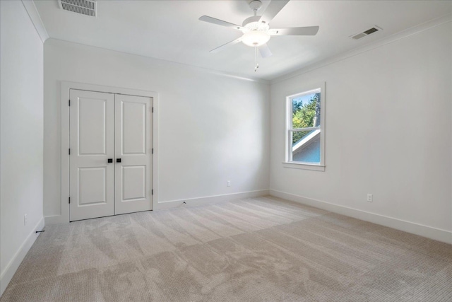 carpeted spare room with crown molding and ceiling fan