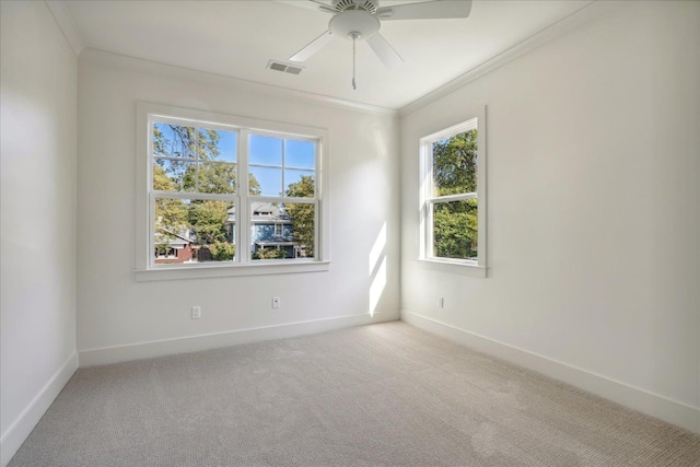 empty room featuring ceiling fan, crown molding, and light carpet