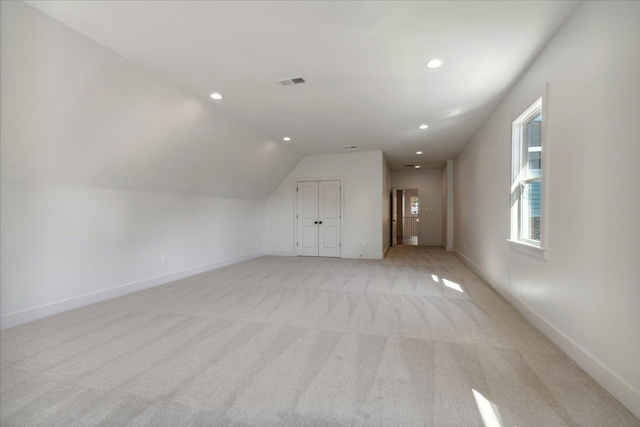 bonus room with light carpet and lofted ceiling