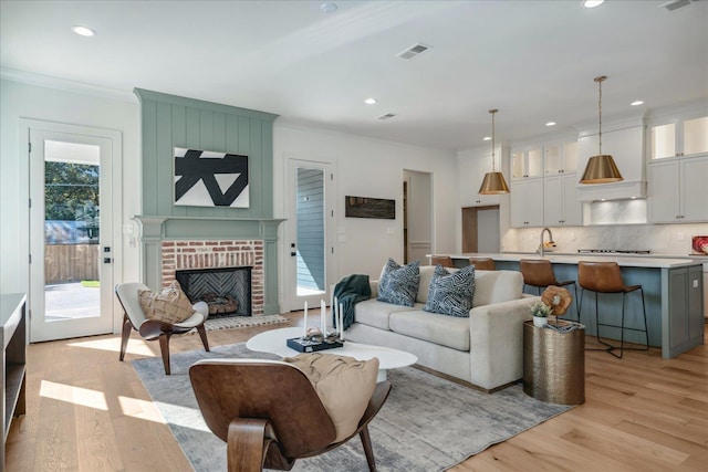 living room featuring light wood-type flooring, plenty of natural light, and a fireplace