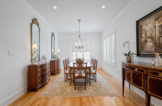 dining area featuring crown molding, light hardwood / wood-style flooring, and a notable chandelier