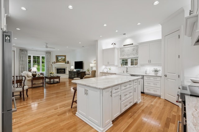 kitchen featuring a kitchen island, light wood-type flooring, white cabinetry, and decorative backsplash