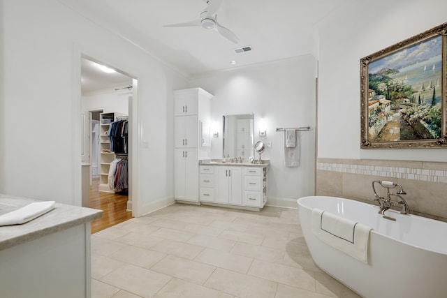 bathroom with ornamental molding, tile patterned floors, vanity, ceiling fan, and a tub