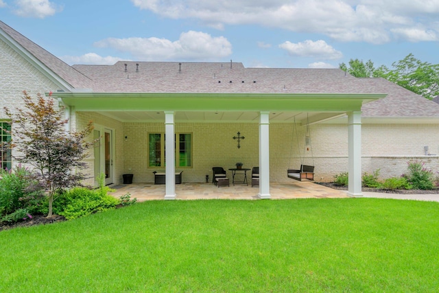 rear view of house with a yard and a patio