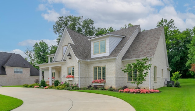 view of front of house with a front lawn, a porch, and central AC