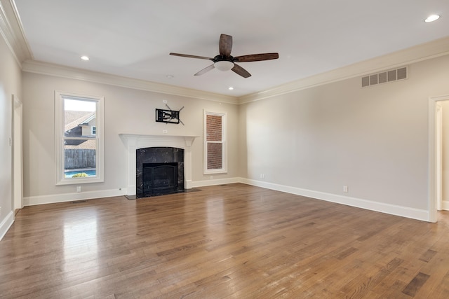 unfurnished living room with a fireplace, hardwood / wood-style floors, ceiling fan, and crown molding